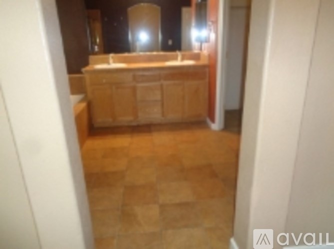 A bathroom with a tiled floor and a wooden vanity.
