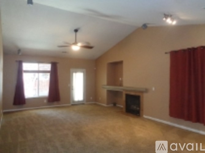 A living room with a fireplace and a fan on the ceiling.