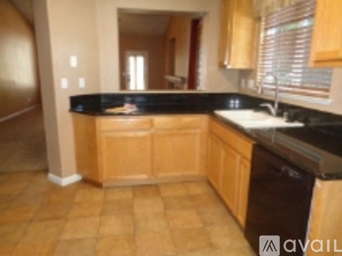 A kitchen with wooden cabinets and black countertops.
