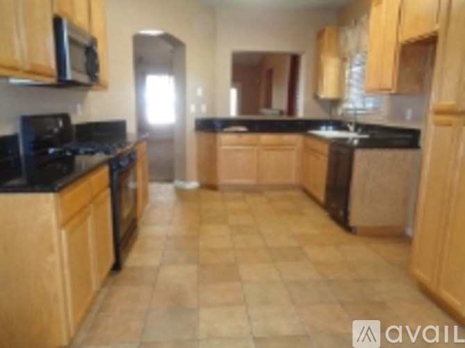 A kitchen with wooden cabinets and black countertops.