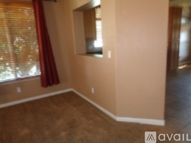 A room with a window and a mirror on the wall.