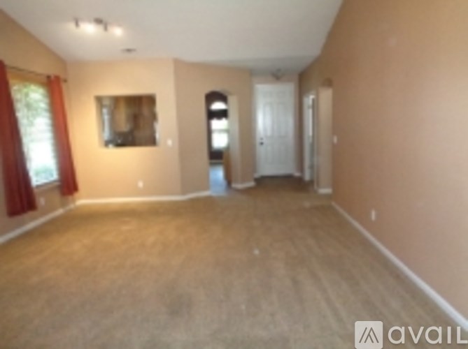 A room with a door and a window with red curtains.