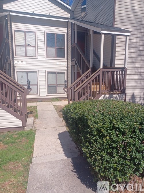 A house with a grey siding and a brown deck.