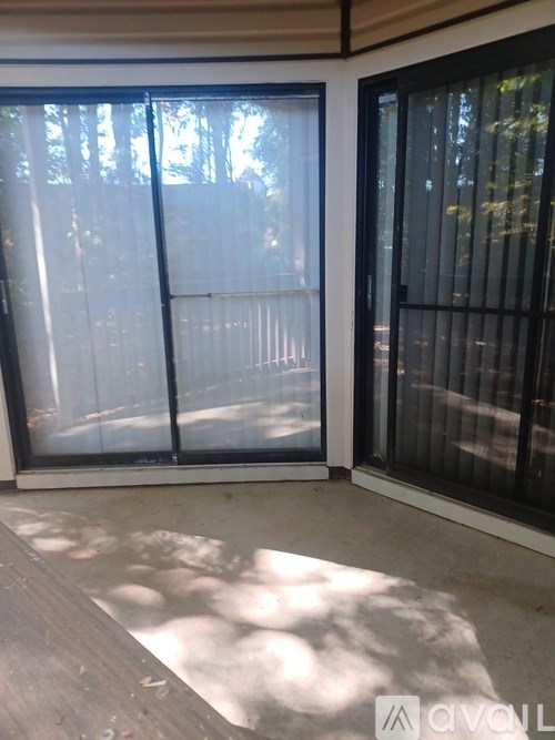 A sliding glass door with a black frame and a view of trees outside.