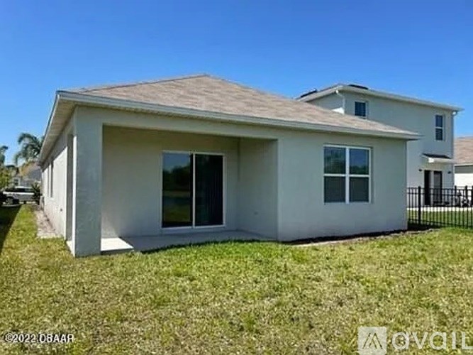 A single-story house with a brown roof and white walls.