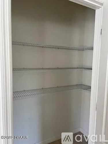 Empty white shelves in a white cabinet.