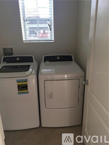 Two front loading washing machines in a small room.