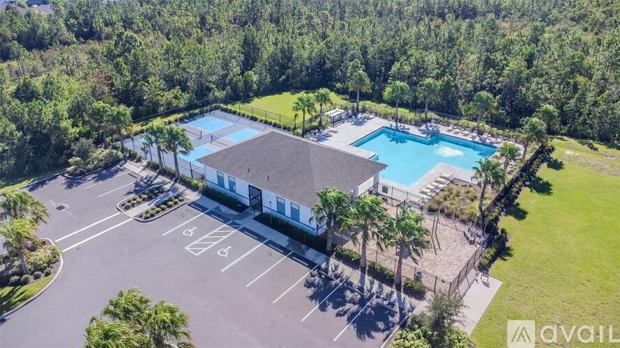 A large outdoor swimming pool surrounded by a grassy area and trees.