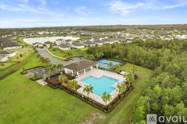A bird's eye view of a house with a pool surrounded by a grassy area.