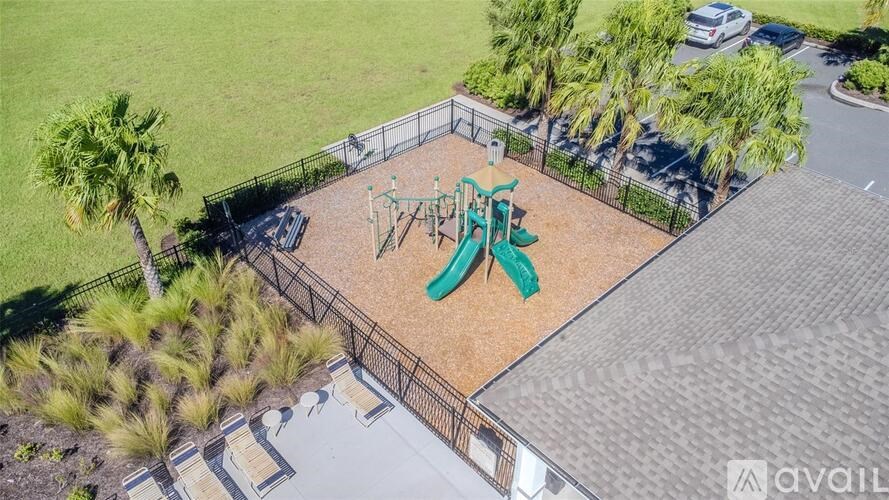 A playground with a green slide and a brown fence.