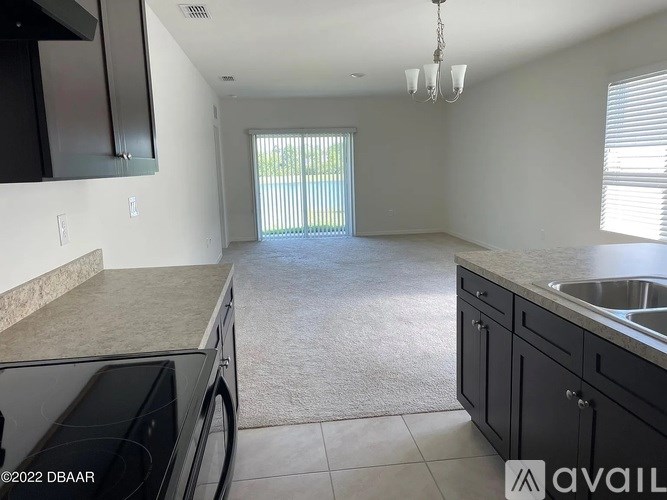 A kitchen with black cabinets and a granite countertop.