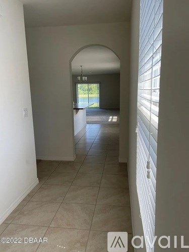 A hallway with a tiled floor and white walls.