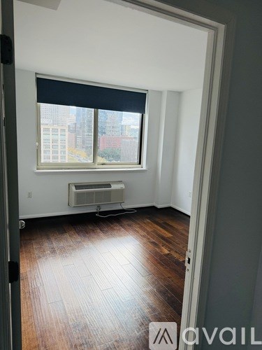 A room with a window and a wall-mounted air conditioner.