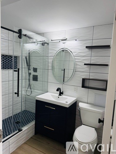 A bathroom with a white toilet, a sink, and a shower.