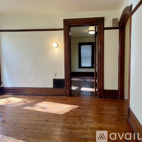 A room with wooden floors and a large mirror on the wall.