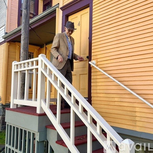 A man in a suit and hat is walking up a staircase.