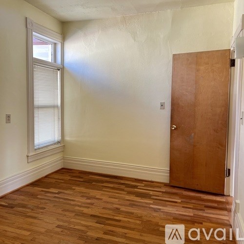 A room with wooden flooring and a door.