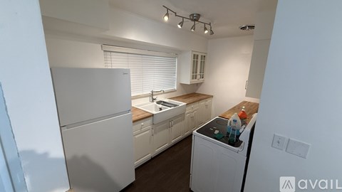 A kitchen with white appliances and wooden countertops.