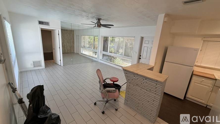 A room with a ceiling fan and a chair in it.
