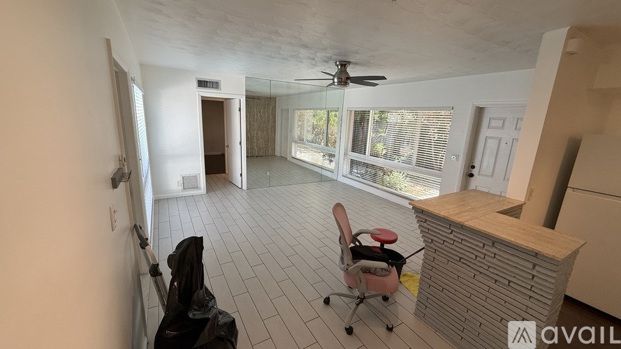 A room with a ceiling fan and a chair with wheels.