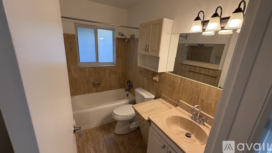 A bathroom with a tub, toilet, and sink.