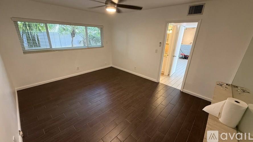 A room with a ceiling fan and a door leading to a balcony.
