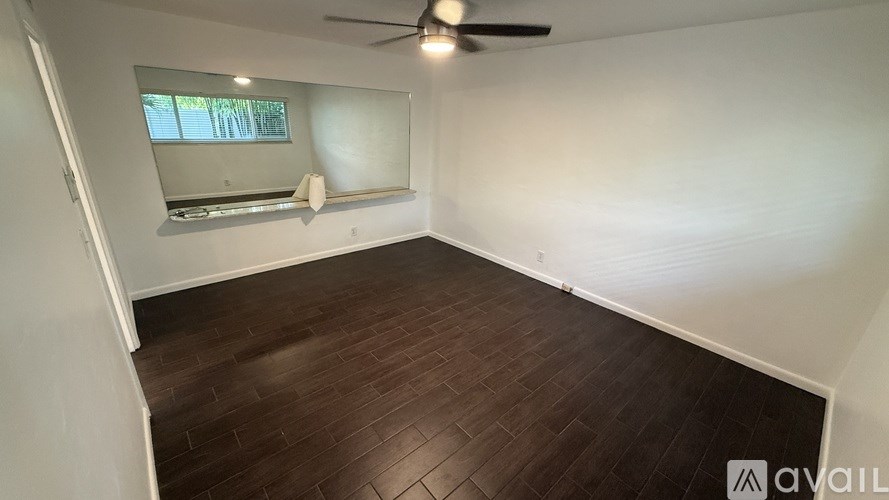 A room with wooden flooring and a ceiling fan.