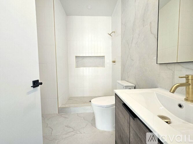 A white bathroom with a toilet, sink, and shower.