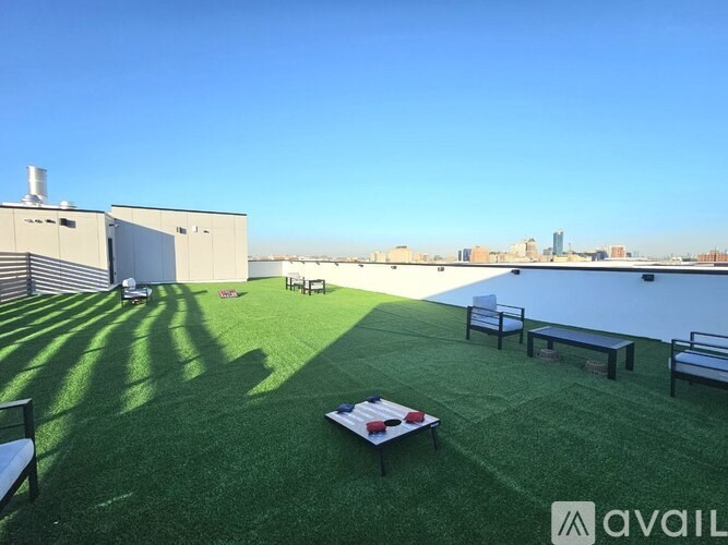 A rooftop patio with a table and chairs overlooking a city skyline.