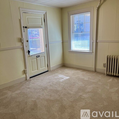A room with a door, window, and radiator.