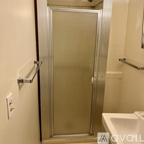 A bathroom with a glass door shower stall and a white sink.