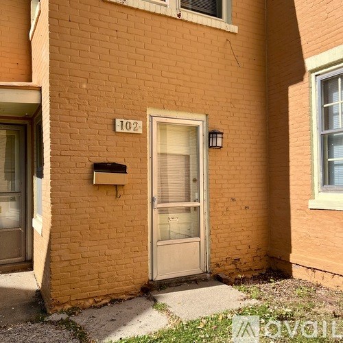 A brick house with the number 102 on it.