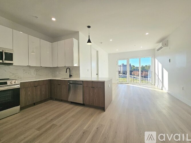 A kitchen with wooden floors and white cabinets is available for rent.