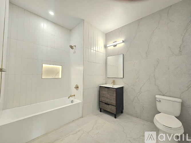 A bathroom with a white tub, sink, and toilet.