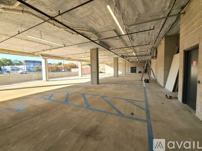 A large, empty parking garage with blue lines on the concrete floor.