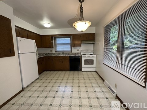 A kitchen with white appliances and a checkered floor.