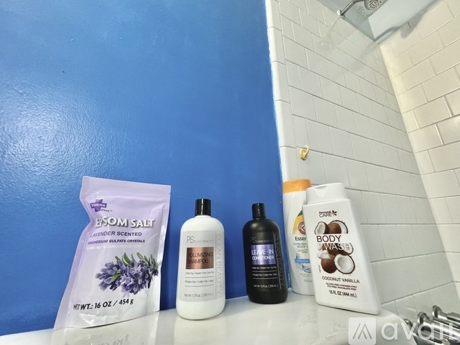 A variety of personal care products are displayed on a bathroom counter.