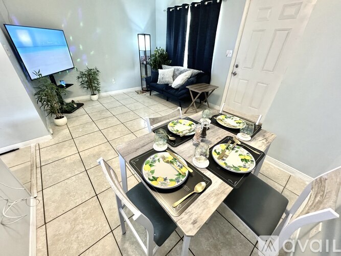 A dining area with a table set for four and a television in the corner.