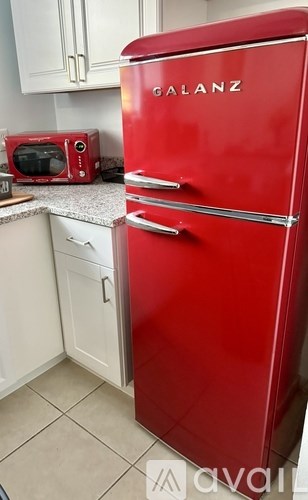 A red Galanz refrigerator in a kitchen.
