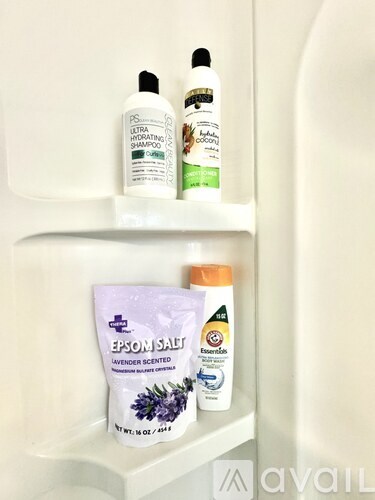 A white shelf with three bottles and a bag of Epsom salt.