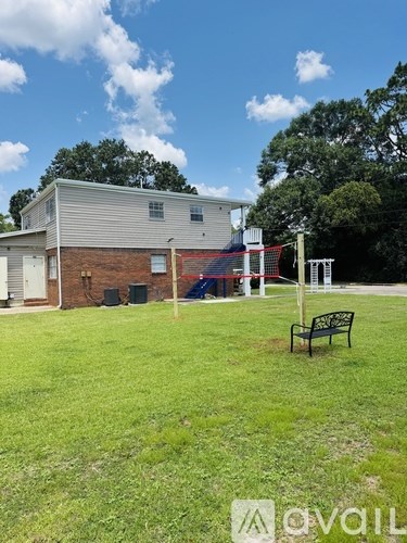 A grassy area with a bench and a building in the background.