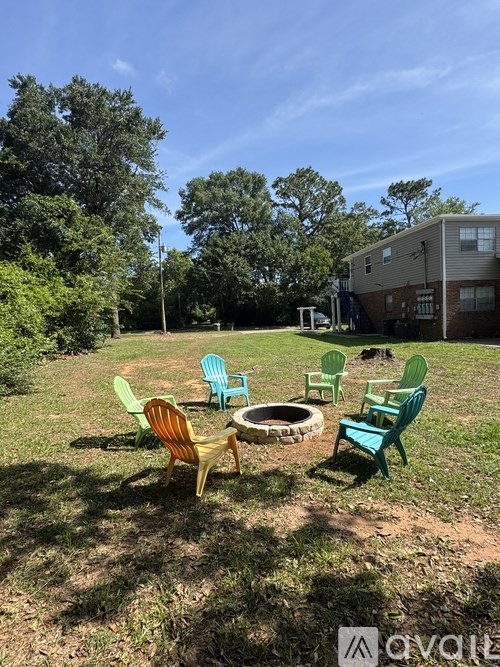 A backyard with a fire pit and chairs.