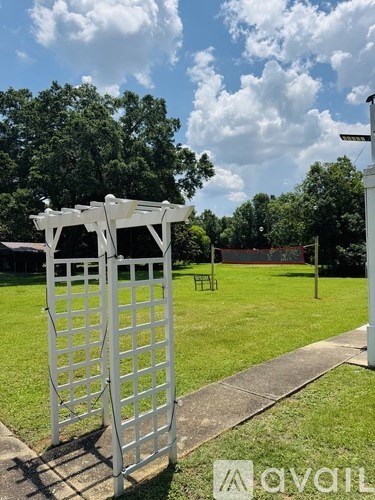 A white gate stands in front of a green field.