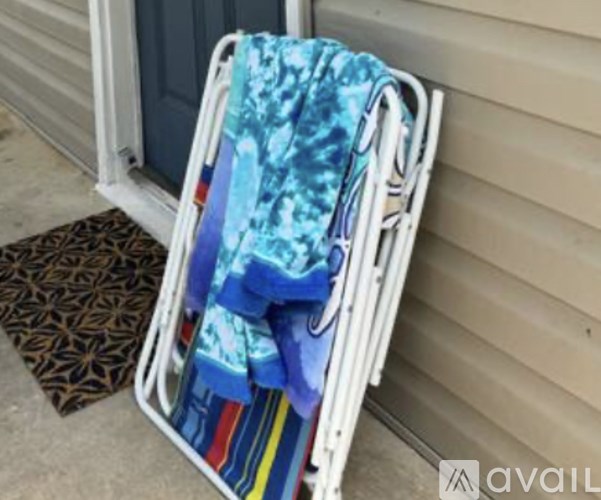 A white folding chair with a blue and white patterned towel draped over it.