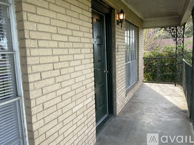 A balcony with a black door and a metal railing.