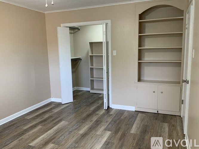 A room with a white door and shelves.
