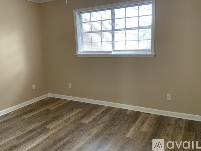 A room with a window and wooden flooring.