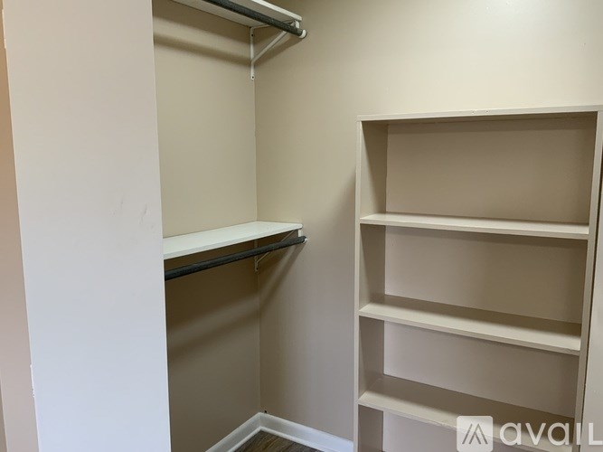 A white closet with shelves and a hanging rod.