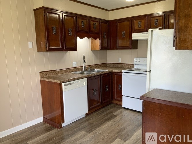 A kitchen with wooden cabinets and a white fridge.