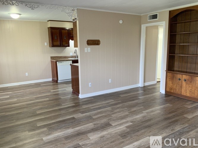 A kitchen area with wooden flooring and a countertop.